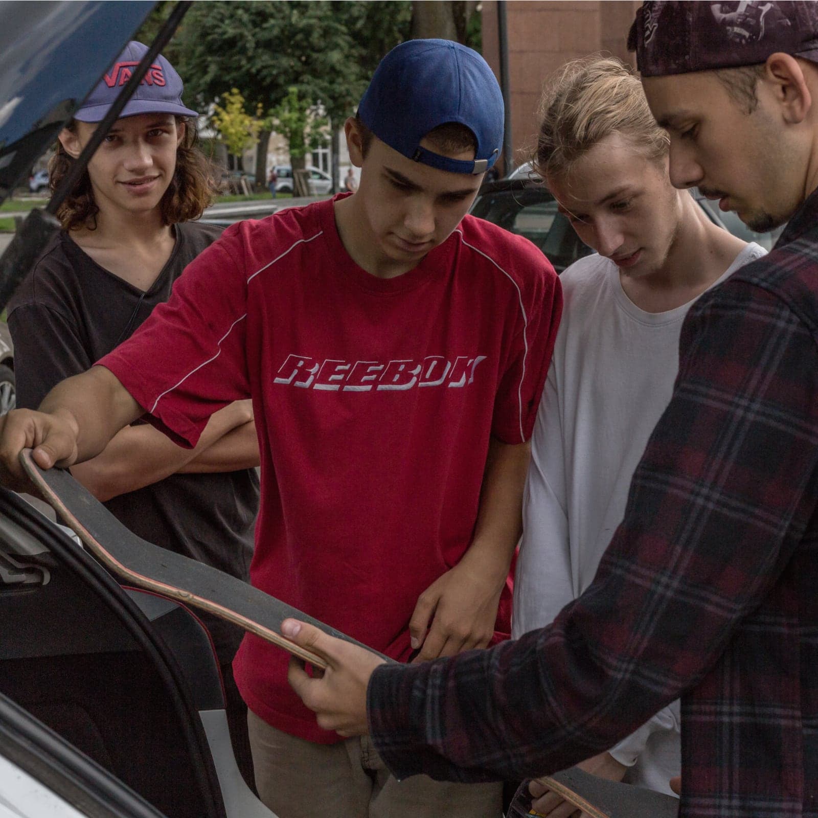 Young skaters in Ukraine inspecting one of the donated decks beside the van