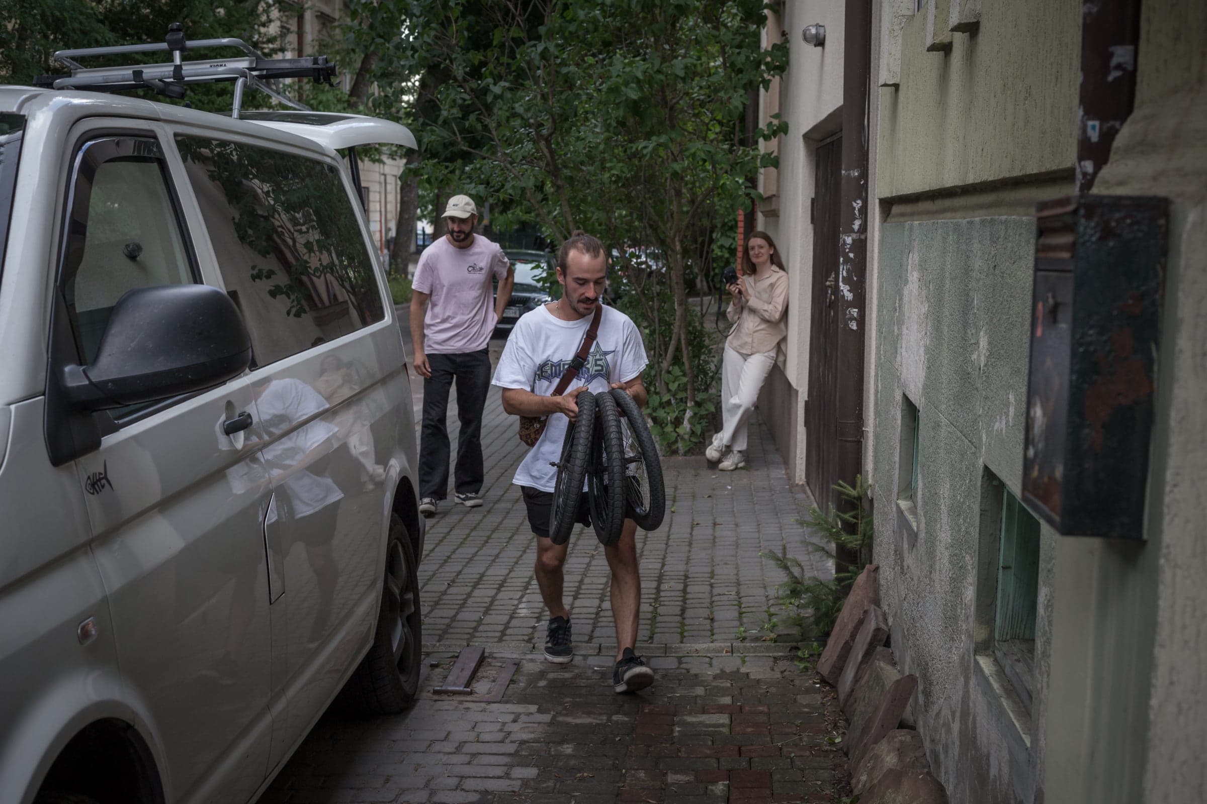 Carrying bike wheels down a side street to the waiting convoy van