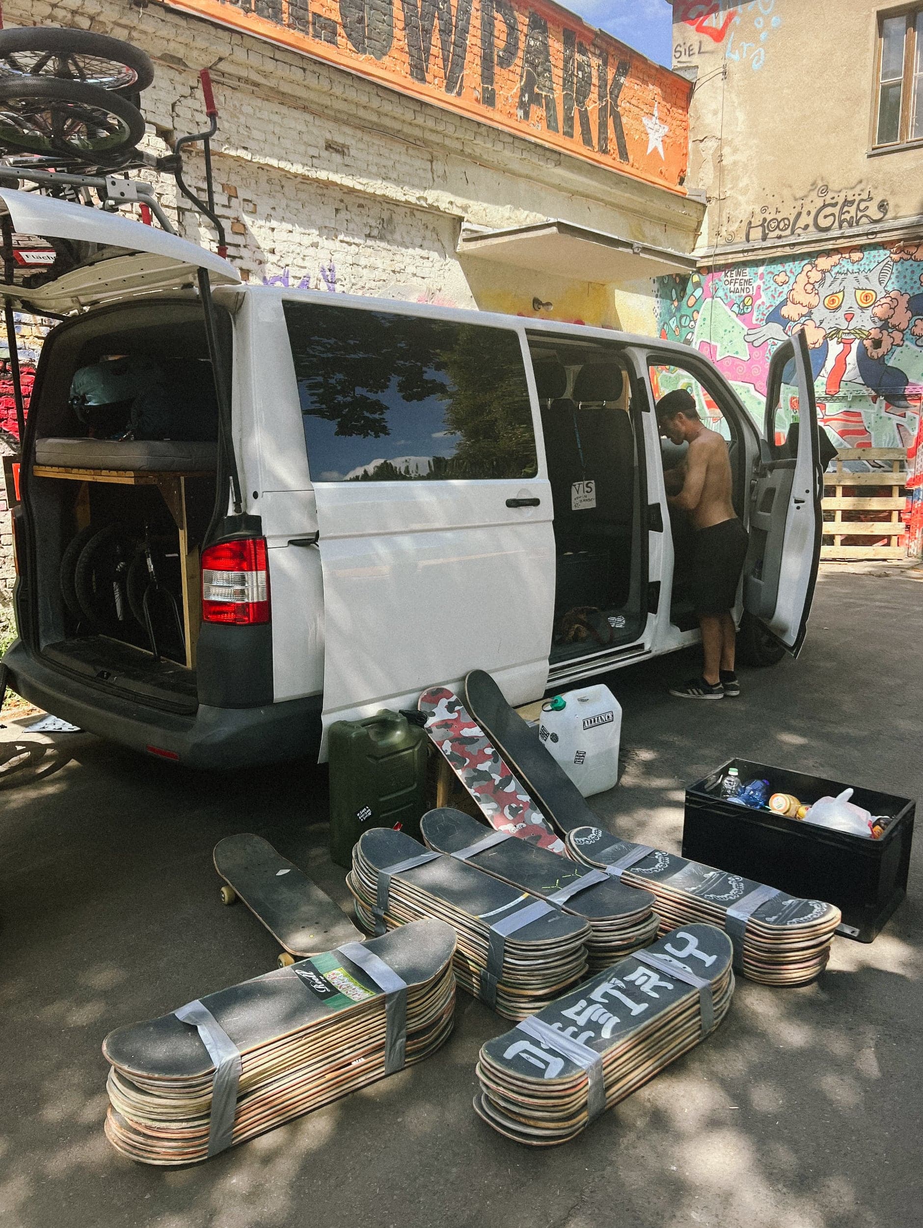 Taped bundles of donated skateboard decks and bikes laid out beside the van before loading