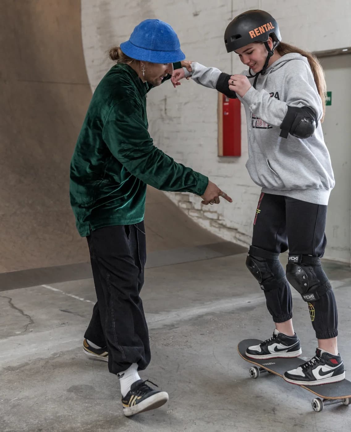 Coach talking a student through her stance during a one-on-one skateboarding lesson